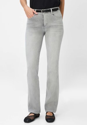 Graue Jeans aus Denim mit geradem Bein, mittelhoher Taille, fünf Taschen und einem schwarzen Gürtel. Tragen mit schwarzen Mesh-Ballerinas.