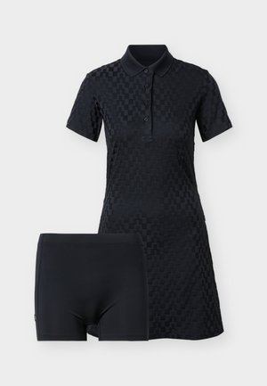 Zwarte textuur korte-mouw polo-jurk met vier knopen, gecombineerd met effen zwarte aansluitende shorts, getoond op een witte achtergrond.