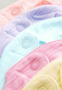 Colorful fabric swatches in pastel shades of pink, lavender, blue, and yellow, featuring ribbed texture and circular buttons.