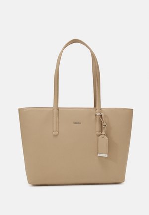 Beżowa torba na ramię o gładkiej syntetycznej powierzchni, z dwoma paskami na ramię i dekoracyjną metką. Posiada subtelne logo z przodu.