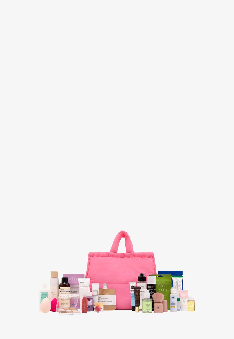 Pink quilted tote bag with two handles, surrounded by various skincare products in different shapes and sizes, featuring colorful packaging.
