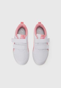 White sneakers with pink lining, featuring two white Velcro straps and Puma branding on tongue and insole.