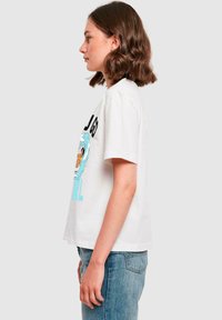 Hvit kortermet t-skjorte med grafisk design av havbølger og teksten "GO GIRL" i blått, med en avslappet passform og myk bomullstekstur.