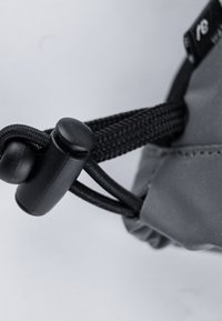 Grau gefütterter Beutel mit einem schwarzen Zugbandverschluss und einem Kunststoffknebel. Die Textur ist glatt, und die Nähte sind deutlich entlang der Ränder sichtbar.