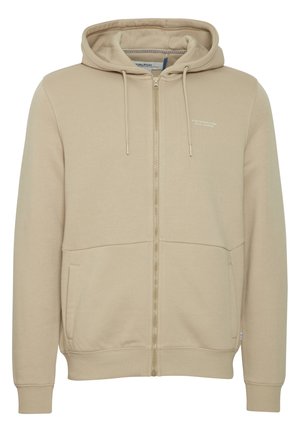 Bežna zip-up kapuca iz mešanice bombaža, z vrvico za nastavitev na kapuci, dvema sprednjima žepoma in diskretno logotipno obdelavo na prsih.