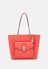 Borsa tote in pelle corallo con tasca frontale a patta, hardware in argento, manici superiori e un piccolo tag con il marchio attaccato. Texture liscia e forma strutturata.