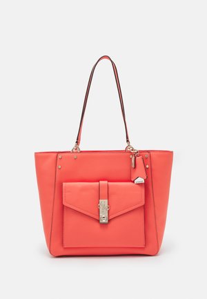 Sac en cuir corail avec une poche avant à rabat, quincaillerie en argent, poignées supérieures et une petite étiquette de marque attachée. Texture lisse et forme structurée.