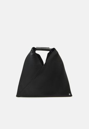 Zwarte tas van glad materiaal met een uniek gedraaid ontwerp, een bovenhandgreep en een subtiel logodetail in de onderste hoek.