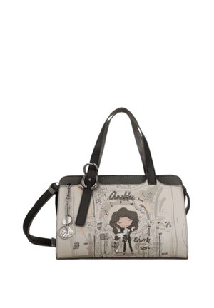 Borsa crema e nera con illustrazione a cartone animato di una donna e un cane, logo "Anekke" e tracolla staccabile, con dettaglio ciondolo in metallo.