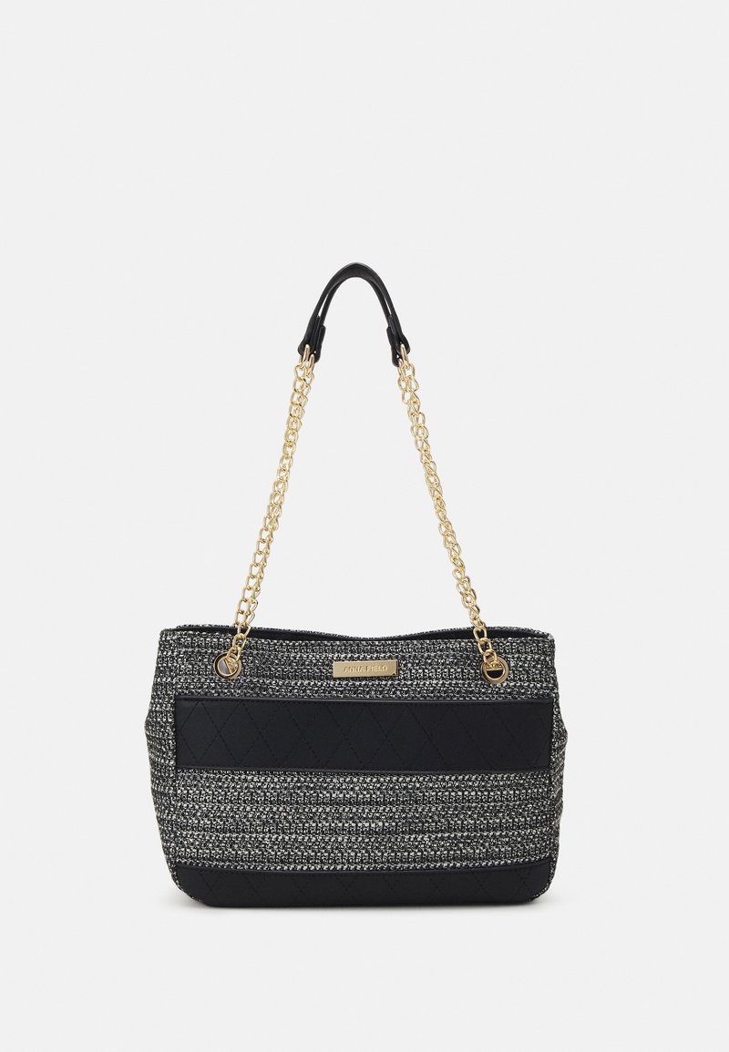 Sac cabas rayé noir et gris avec texture matelassée, bretelles en chaîne dorée et plaque logo à l'avant. Tissu solide avec un design spacieux.