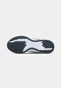 Semelle de sneaker en caoutchouc noir et blanc ; présente un motif de grip texturé et des détails de logo. Forme courbée pour une meilleure traction.