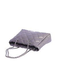 Bolso de mano gris de cuero sintético acolchado con forma rectangular. Cuenta con una correa de cadena y una etiqueta de logo sutil. Textura suave y acabado brillante.