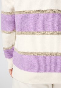 Garen trui met verticale strepen in crème, lavendel en metallic gouden accenten; textuurstof, losse pasvorm, ribbelrand en manchetten.