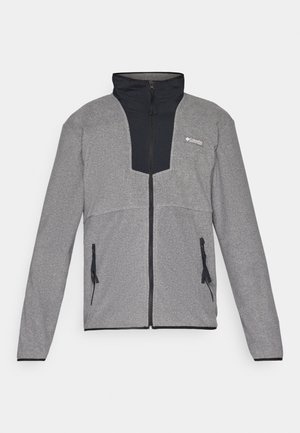 Pilkas švarkas su juodu apykakle ir užtrauktuku priekyje. Turinti kontrastingas tamsias ir šviesias pilkas dalis, užtrauktukus kišenėse ir minkštą tekstūrą.