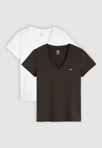 Deux t-shirts à col en V, en noir et blanc, fabriqués en coton doux, avec des manches courtes et un petit logo rouge sur le t-shirt noir.