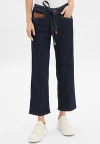 Pantalons en denim à jambes larges de couleur bleu foncé avec une finition texturée ; dotés d'une taille ceinturée, de poches accents marron et de surpiqures contrastées.