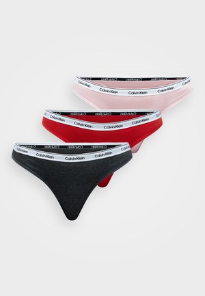 Tri pary tangic spodnjega perila Calvin Klein v črni, rdeči in roza barvi, ki imajo mehak material, nizko postavljen kroj in elastičen pas z logotipom.