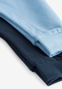 Zwei umgeschlagene Ärmel von Bekleidung, einer in Hellblau und der andere in Dunkelblau, aus einem weichen Baumwollmischgewebe mit glatter Textur.