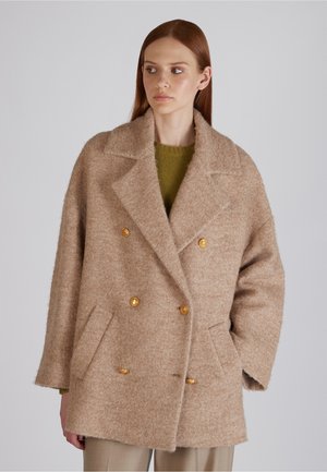 Cappotto doppio petto beige in misto lana con colletto a rever, grandi bottoni dorati e tasche a patta. Superficie morbida e testurizzata, vestibilità rilassata.