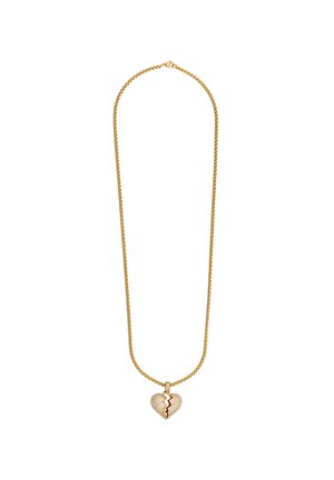 Collana in oro con pendente a forma di cuore spezzato, caratterizzato da una superficie texturizzata e un accento rosso. La catena presenta un design attorcigliato.