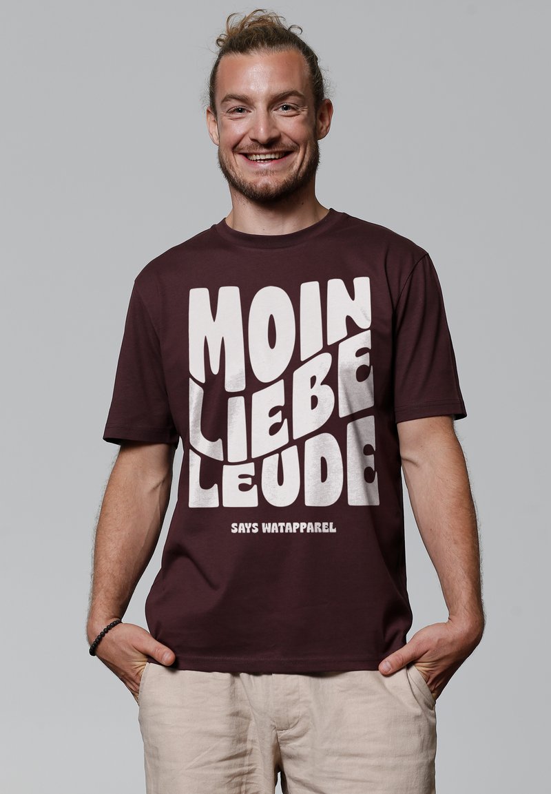 Bordeauxfarbnes Baumwoll-T-Shirt mit einem auffälligen weißen Grafikdesign, das auf der Vorderseite "MOIN LIEBE LEUTE" und "SAYS WATAPAREL" liest. Kurze Ärmel, runder Hals.