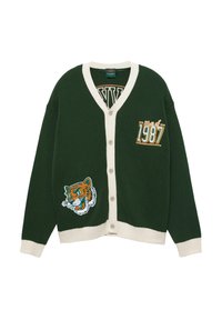 Cardigan a bottoni verde scuro con bordo crema, testo "Class of 1987" sul petto e una patch con la testa di una tigre nella parte inferiore anteriore.