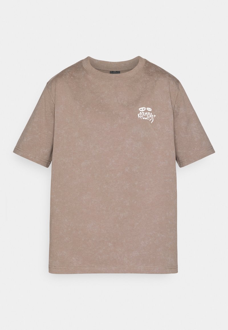 Light brown washed cotton T-shirt with short sleeves and small white graphic logo on the upper left chest reading "Karma" with eyes above.