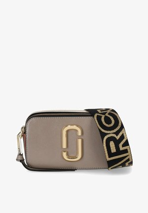 Sac transversal en matériau synthétique beige avec une finition texturée, doté d'un fermoir doré, d'une bandoulière noire avec une inscription dorée, et d'une fermeture éclair.