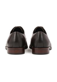 Scarpe da uomo in pelle marrone con finitura liscia e punta arrotondata, dotate di tacco basso impilato e un accento in legno. Vista posteriore mostrata.
