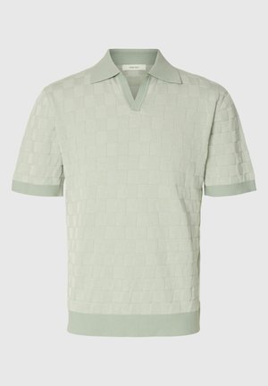 Heleroheline lühikeste varrukatega kudumiga polosärk, millel on tekstuuriga ruuduline muster ja V-kaelusega krae.