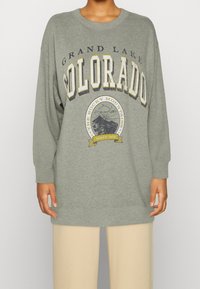 Felpa oversized grigia con la scritta "GRAND LAKE COLORADO" in vari stili, un grafiche di montagne e polsini e orlo a costine.