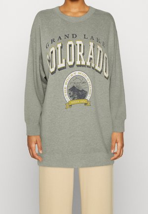 Sudadera gris de gran tamaño con el texto "GRAND LAKE COLORADO" en varios estilos, acompañada de un gráfico de montaña y puños y dobladillo acanalados.