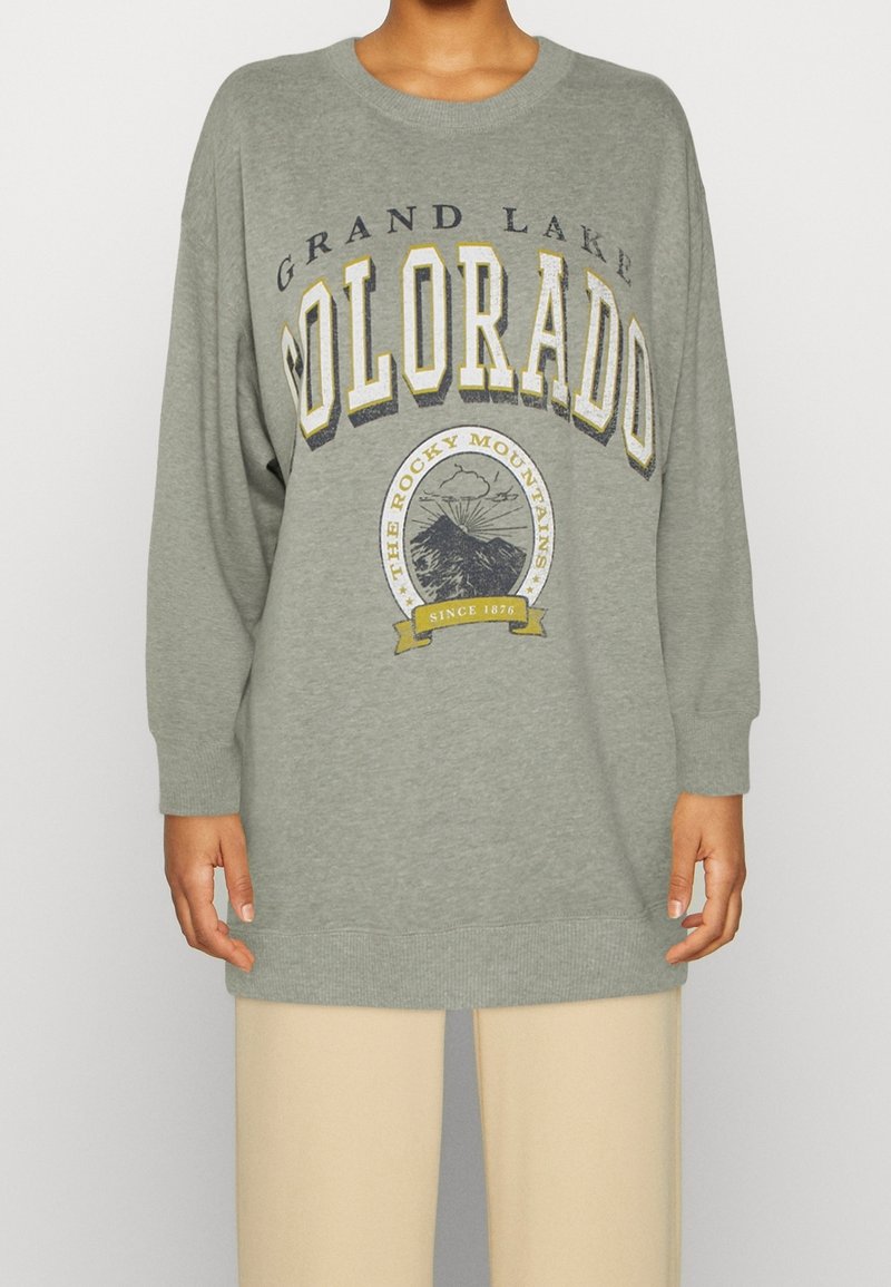 Felpa oversized grigia con la scritta "GRAND LAKE COLORADO" in vari stili, un grafiche di montagne e polsini e orlo a costine.