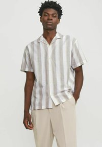 Camisa de manga corta, con botones, en colores claros y con rayas verticales. Fabricada en una tela ligera, presenta un cuello tipo camp y un corte relajado.