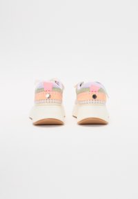Vista posteriore di sneaker colorate che presentano una combinazione di tessuti rosa, verde e bianco; suola spessa; e dettagli di brand sul tallone.