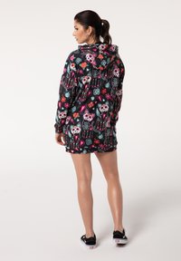 Schwarzes Sweatkleid mit bunten Schädel- und Katzenmotiven, floralen Mustern und einer lockeren Passform. Mit Kapuze und langen Ärmeln akzentuiert.