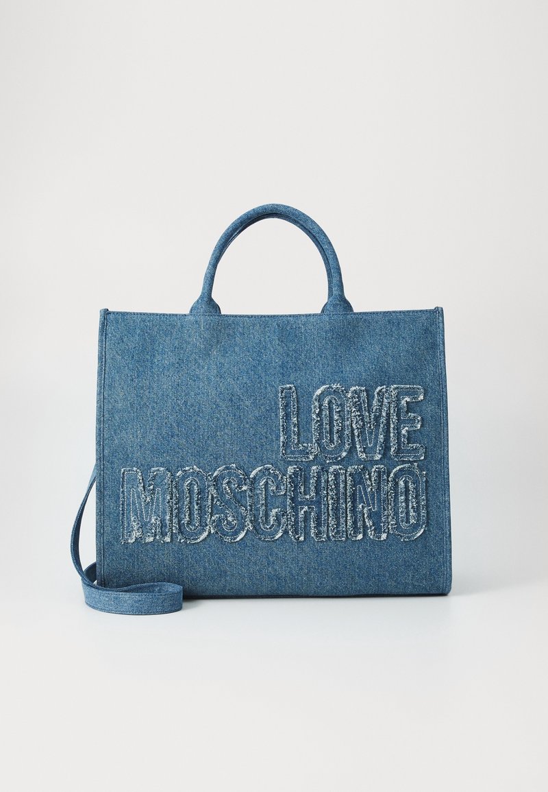 Sac cabas en denim bleu Love Moschino avec poignées courtes et bandoulière réglable sur fond blanc.