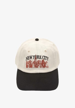 Casquette couleur crème avec une visière noire. "NEW YORK CITY" est brodé en noir au-dessus d'une illustration de la silhouette de la ville en rouge. Matière en coton.