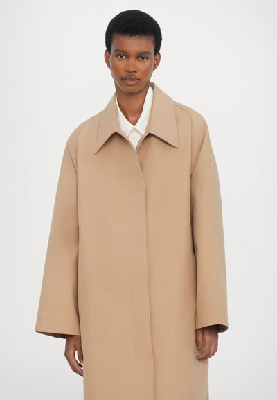 Light brown, oversized coat with a wide collar and straight cut. Fabric appears smooth, with no visible fastenings or patterns.