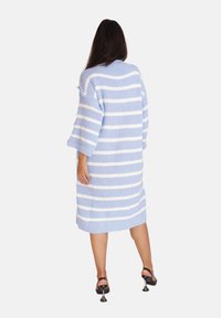 Übergroßes blau-weiß gestreiftes Strickkleid mit Dreiviertelärmeln und rundem Ausschnitt. Textil mit strukturierter Oberfläche und lockerer Passform.