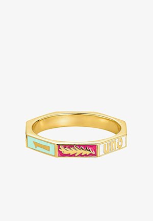 Anillo hexagonal de oro con tres paneles de esmalte que muestran un número uno dorado sobre azul, una hoja dorada sobre rojo y la palabra "uno" en blanco.