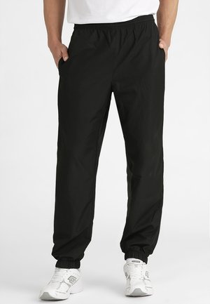 Czarne spodnie sportowe wykonane z lekkiego materiału, z elastycznym pasem, bocznymi kieszeniami oraz elastycznymi ściągaczami na kostkach.