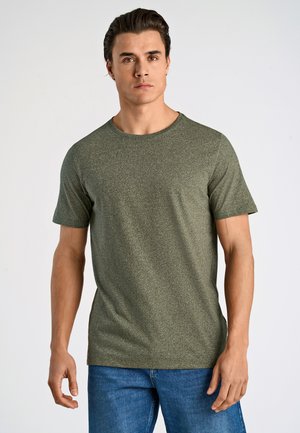 T-shirt corto verde oliva realizzato in tessuto texturizzato, con scollatura tonda e taglio dritto. Abbinato a jeans denim blu.