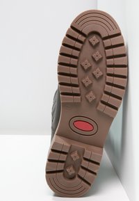 Suola in gomma con un profondo modello di battistrada, colore marrone, caratterizzata da un prominente accento rosso circolare e la marcatura della taglia "37". Texturizzata per una migliore aderenza.