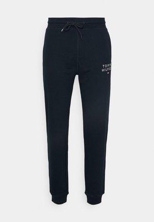 Námořnické modré tepláky z měkkého materiálu, s elastickým pasem a šňůrkou, a malým vyšitým logem na levém stehně.