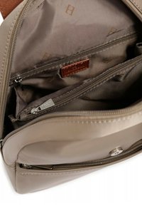 Borsa beige con una superficie liscia, dotata di più scomparti, una tasca con zip e un'accensione in pelle marrone all'interno.