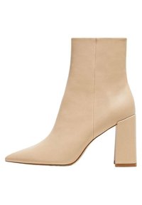 Botín beige de tobillo confeccionado en cuero liso, con puntera puntiaguda y tacón cuadrado. Diseño minimalista sin herrajes visibles ni estampados.