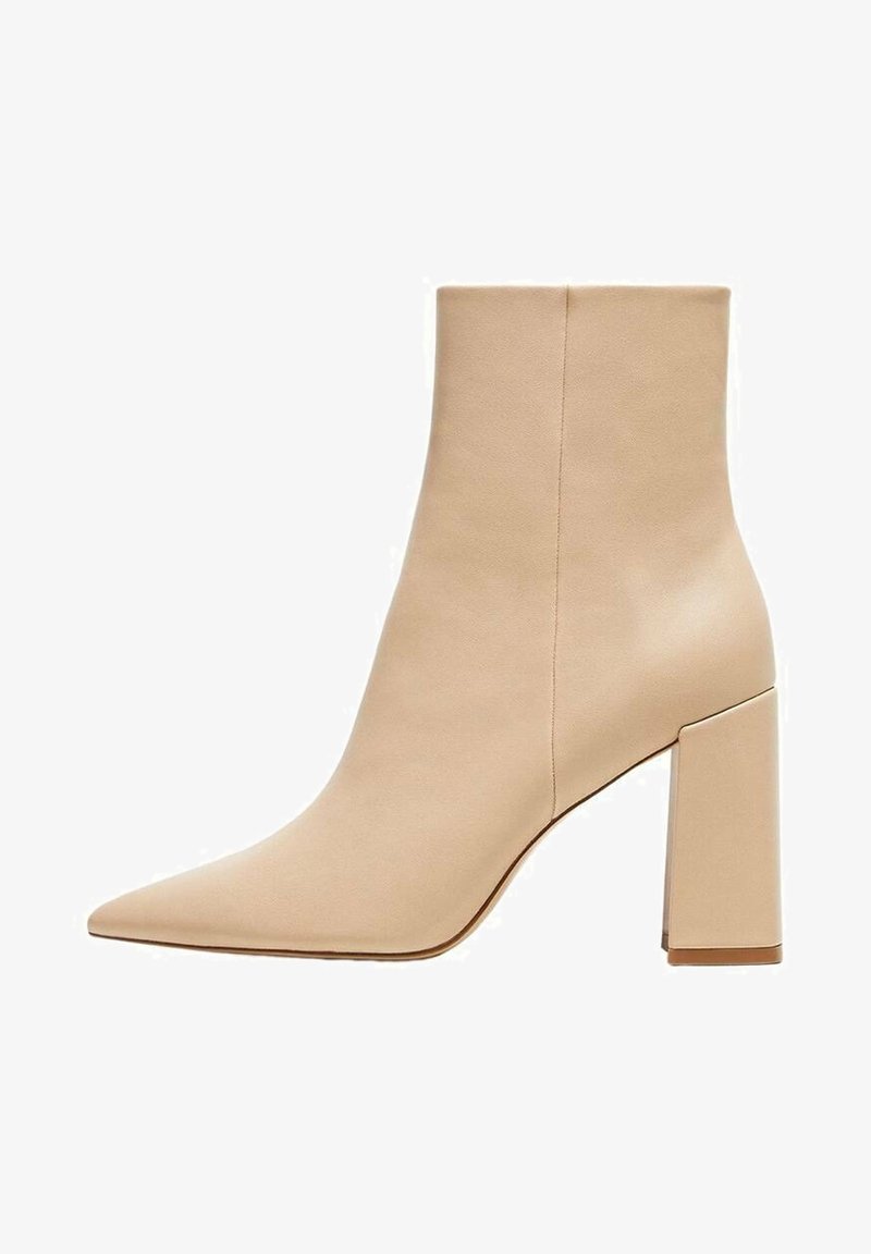 Botín beige de tobillo confeccionado en cuero liso, con puntera puntiaguda y tacón cuadrado. Diseño minimalista sin herrajes visibles ni estampados.