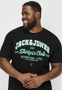 Schwarzes Baumwoll-T-Shirt mit weißem und mintgrünem grafischem Text. Runder Ausschnitt und kurze Ärmel. Mit "Jack & Jones Surfer's Club" Design.