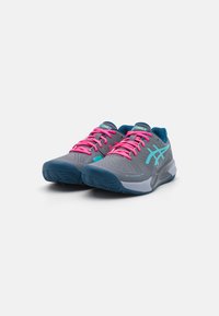 Scarpe sportive con tomaia grigia, dettagli blu e lacci rosa. Presentano motivi testurizzati e una suola in gomma per una maggiore aderenza.